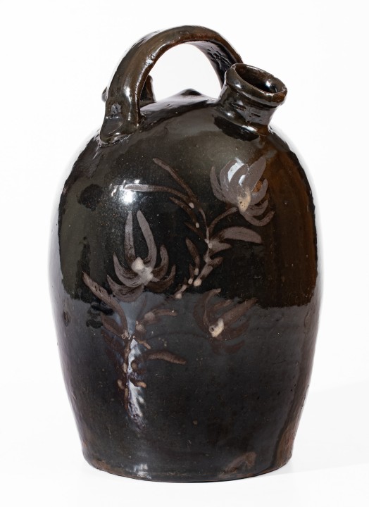 Extremely Rare Albany-Slip-Glazed Stoneware Harvest Jug with White-Slip Floral Decoration, attributed to the Hyssong Family, Cassville, PA, fourth quarter 19th century.