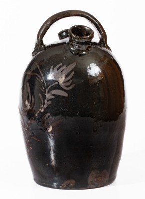 Extremely Rare Albany-Slip-Glazed Stoneware Harvest Jug with White-Slip Floral Decoration, attributed to the Hyssong Family, Cassville, PA, fourth quarter 19th century.