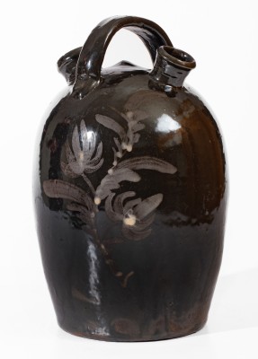 Extremely Rare Albany-Slip-Glazed Stoneware Harvest Jug with White-Slip Floral Decoration, attributed to the Hyssong Family, Cassville, PA, fourth quarter 19th century.