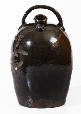 Extremely Rare Albany-Slip-Glazed Stoneware Harvest Jug with White-Slip Floral Decoration, attributed to the Hyssong Family, Cassville, PA, fourth quarter 19th century.